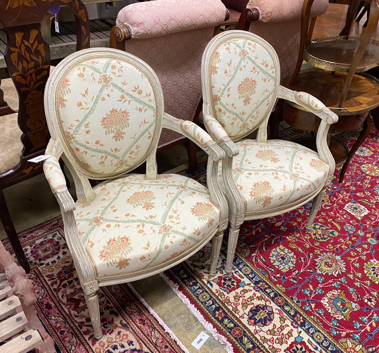 A pair of Louis XVI style cream painted fauteuils, width 58cm, height 90cm